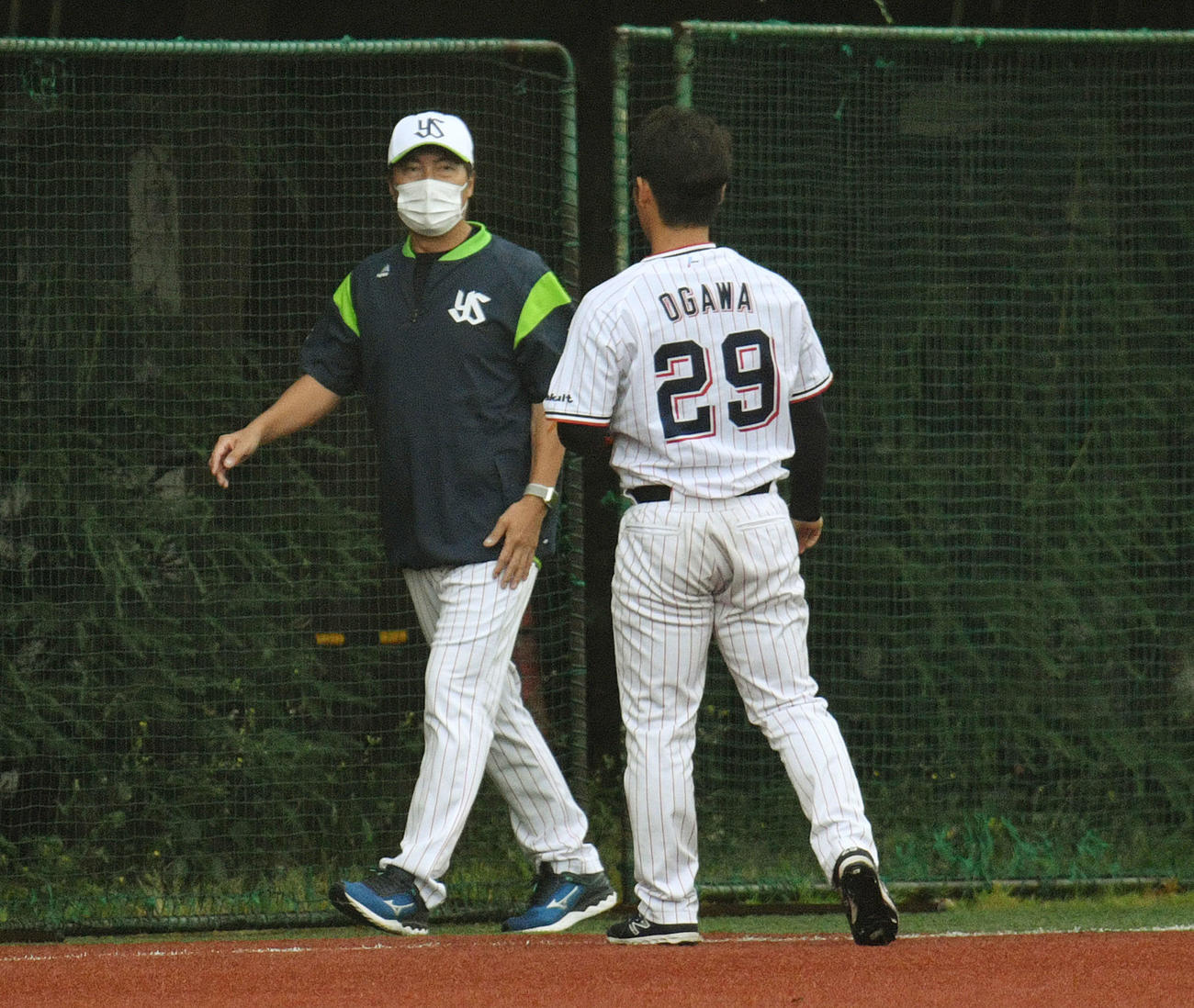 ヤクルト対楽天　練習試合が悪天候で中止となりキャッチボールするヤクルト小川（手前）に話しかける高津監督（撮影・滝沢徹郎）