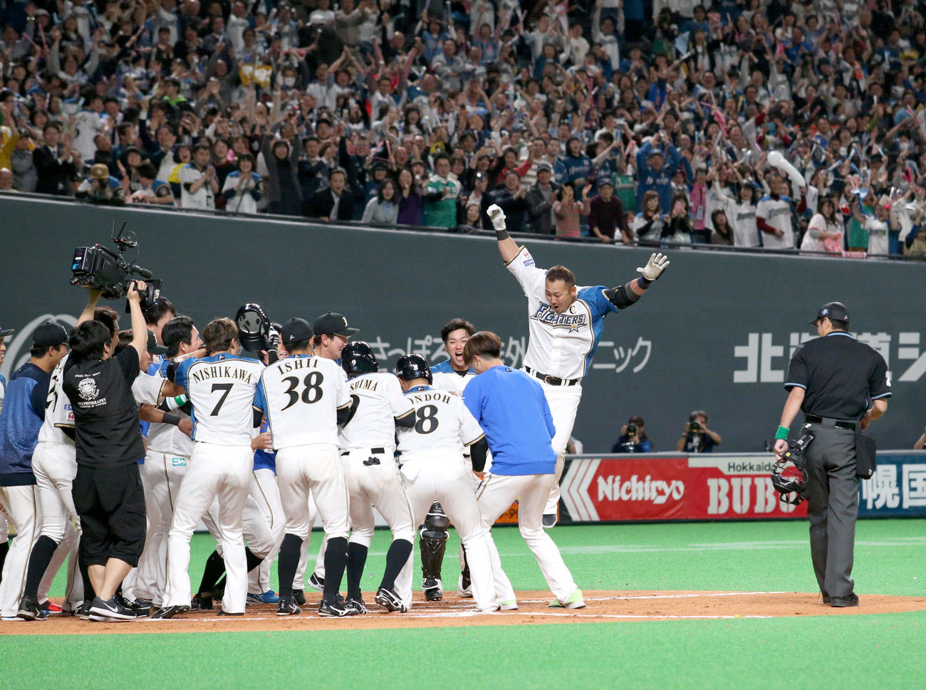 19年3月29日、オリックスとの開幕戦でサヨナラ満塁本塁打を放ちチームメートに出迎えられる日本ハム中田