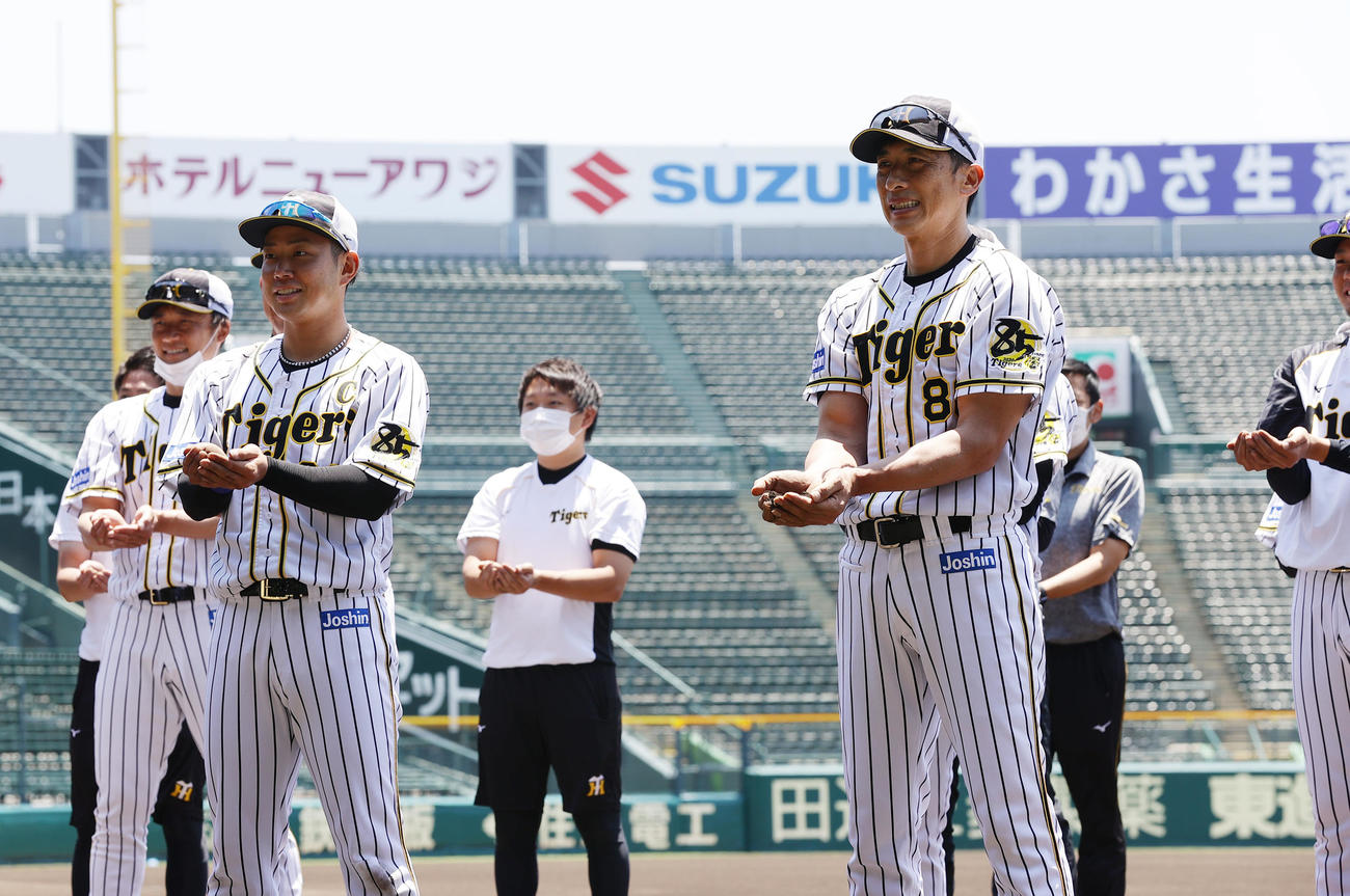 練習開始を前に土を集める矢野耀大監督（右）、糸原健斗ら阪神の選手たち