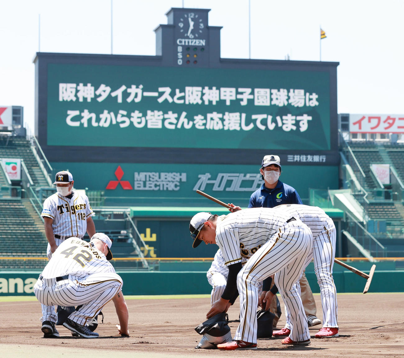 練習開始を前に土を集める北條史也（右）ら阪神の選手たち（撮影・清水貴仁）