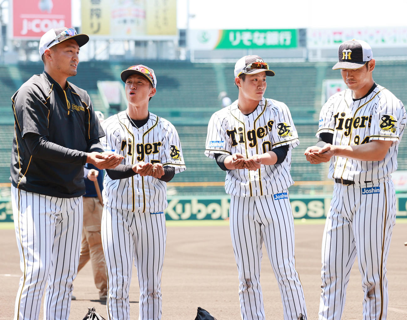 練習開始を前に土を集める阪神の選手たち、左から秋山拓巳、近本光司、木浪聖也、原口文仁（撮影・清水貴仁）
