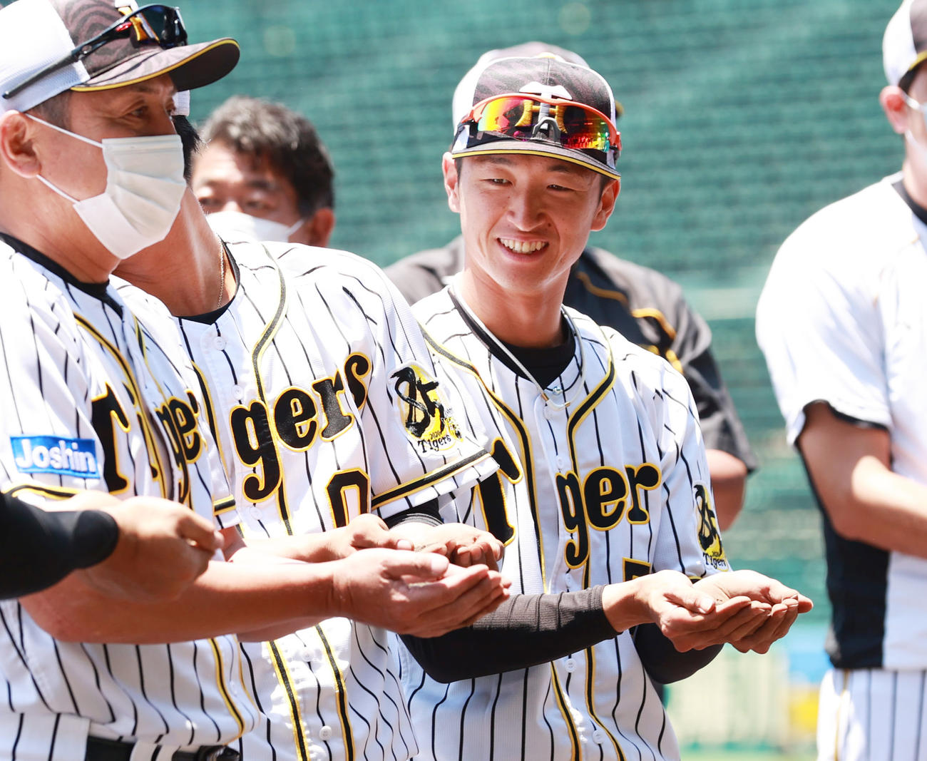 練習開始を前に土を集める近本ら阪神の選手たち（撮影・清水貴仁）