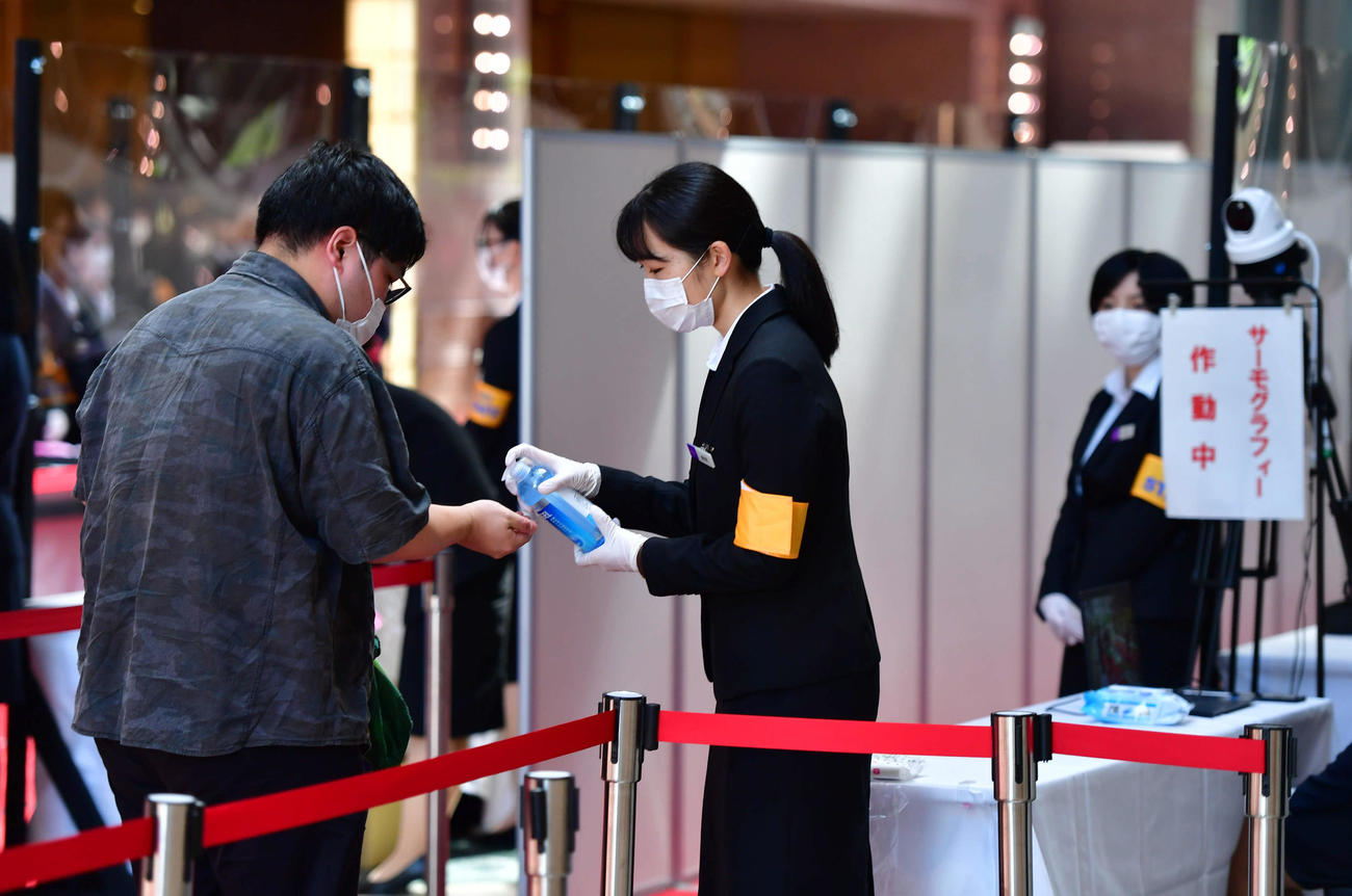 阪急阪神ホールディングスの定時株主総会の会場へ向かう株主に、手指のアルコール消毒とサーモグラフィーによる検温が行われた（撮影・岩下翔太）