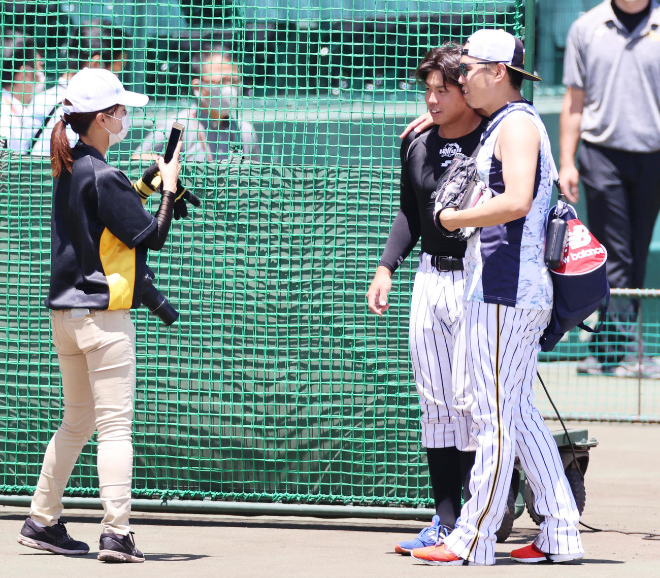 球団オフィシャルのカメラに向け肩を組む西勇輝（右）と梅野隆太郎（撮影・清水貴仁）