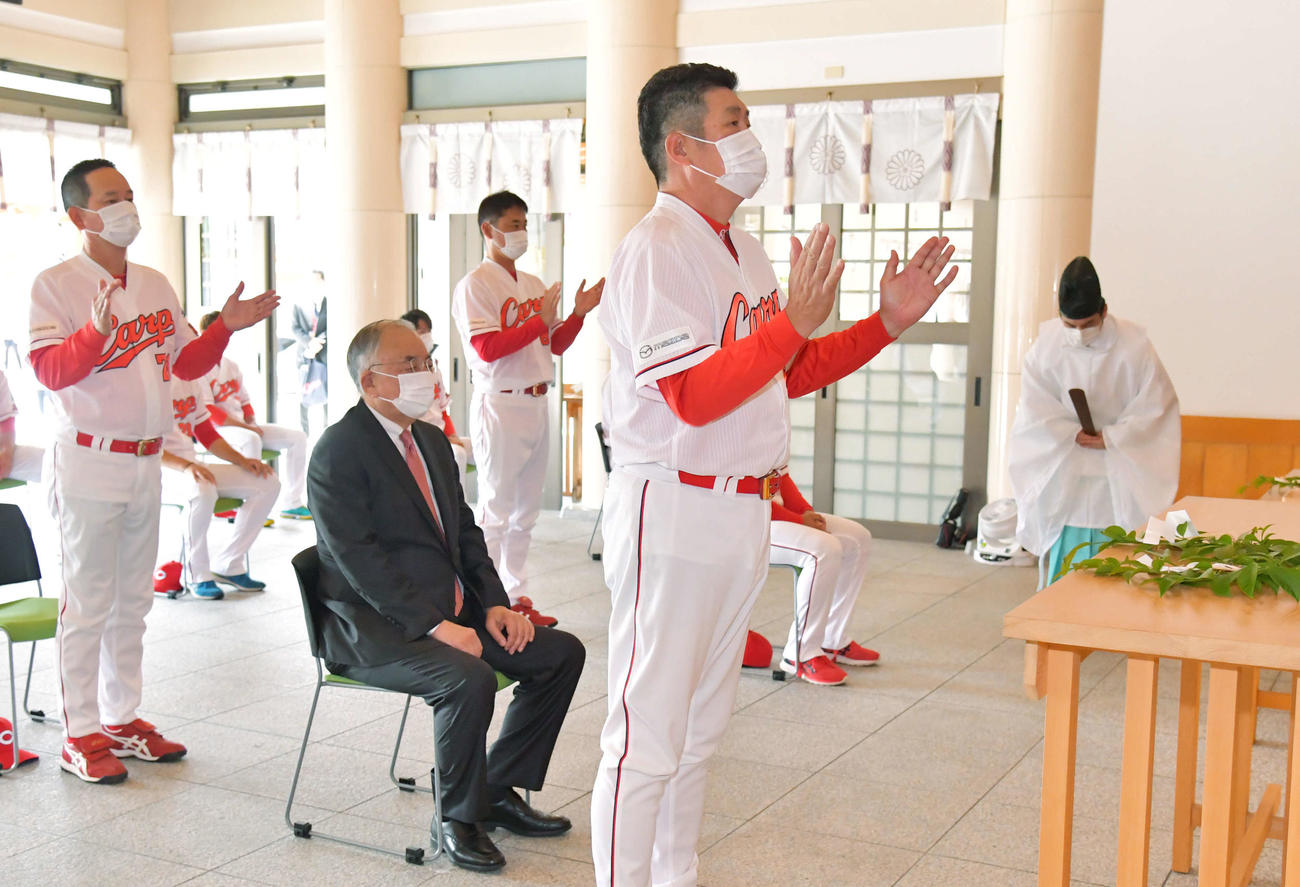 広島護国神社で必勝祈願をする広島佐々岡監督（中央）。左隣は松田オーナー。左端は高ヘッドコーチ