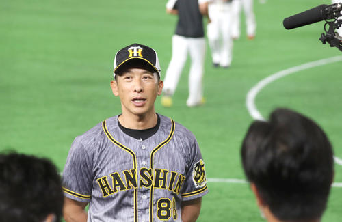 開幕前日練習を行うナインを背にインタビューを受ける矢野監督（撮影・加藤哉）