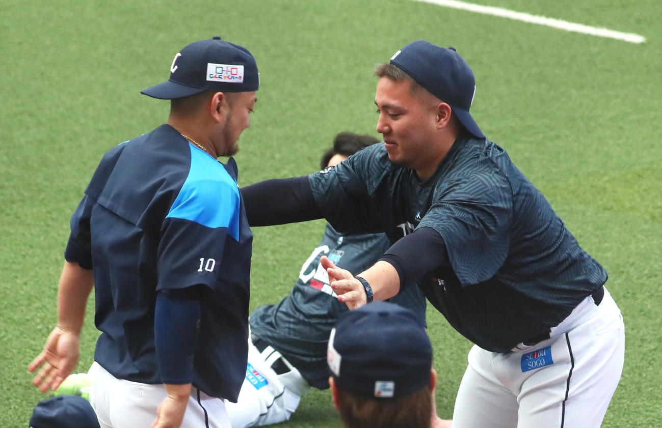 練習前、手押し相撲を楽しむ西武の森（左）と山川（撮影・足立雅史）