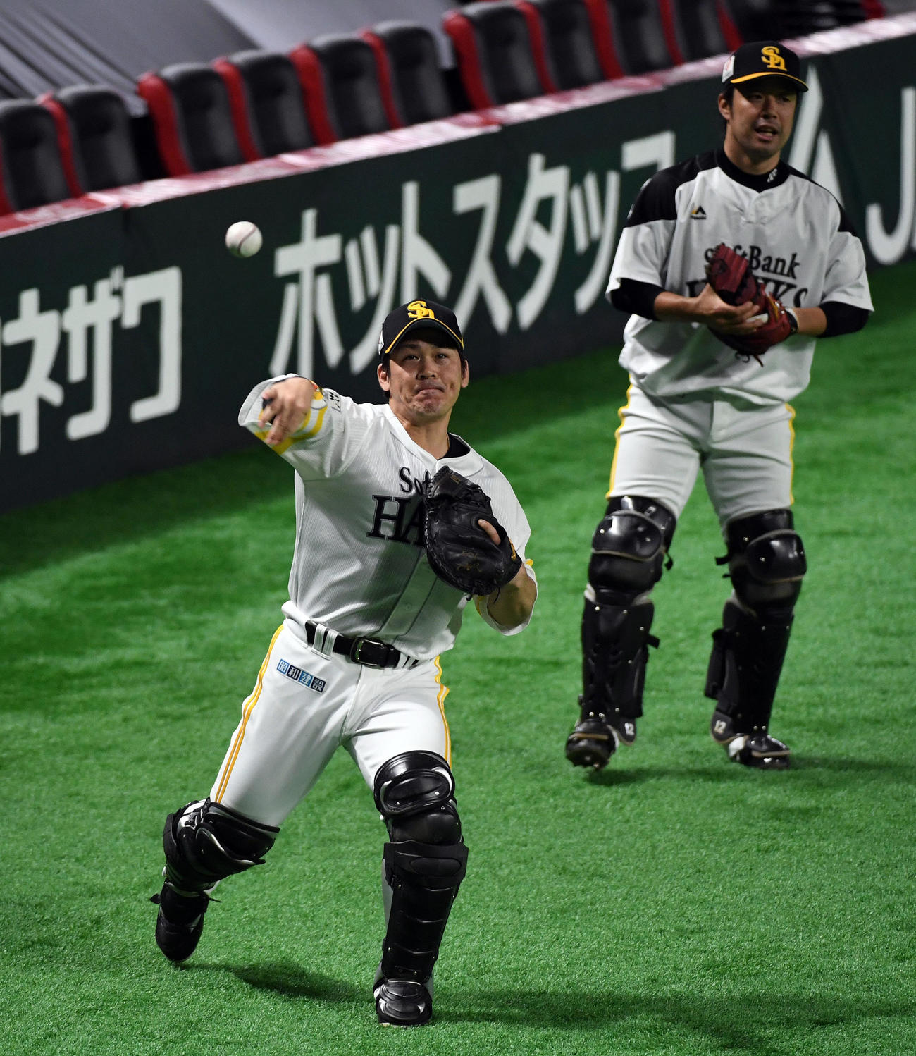 捕手の送球練習するソフトバンク甲斐拓也、後方は高谷裕亮（撮影・今浪浩三）