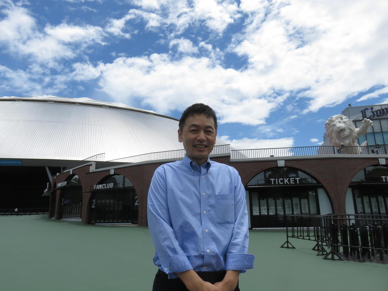 メットライフドームをバックに写る西武井上事業部長（撮影・栗田成芳）