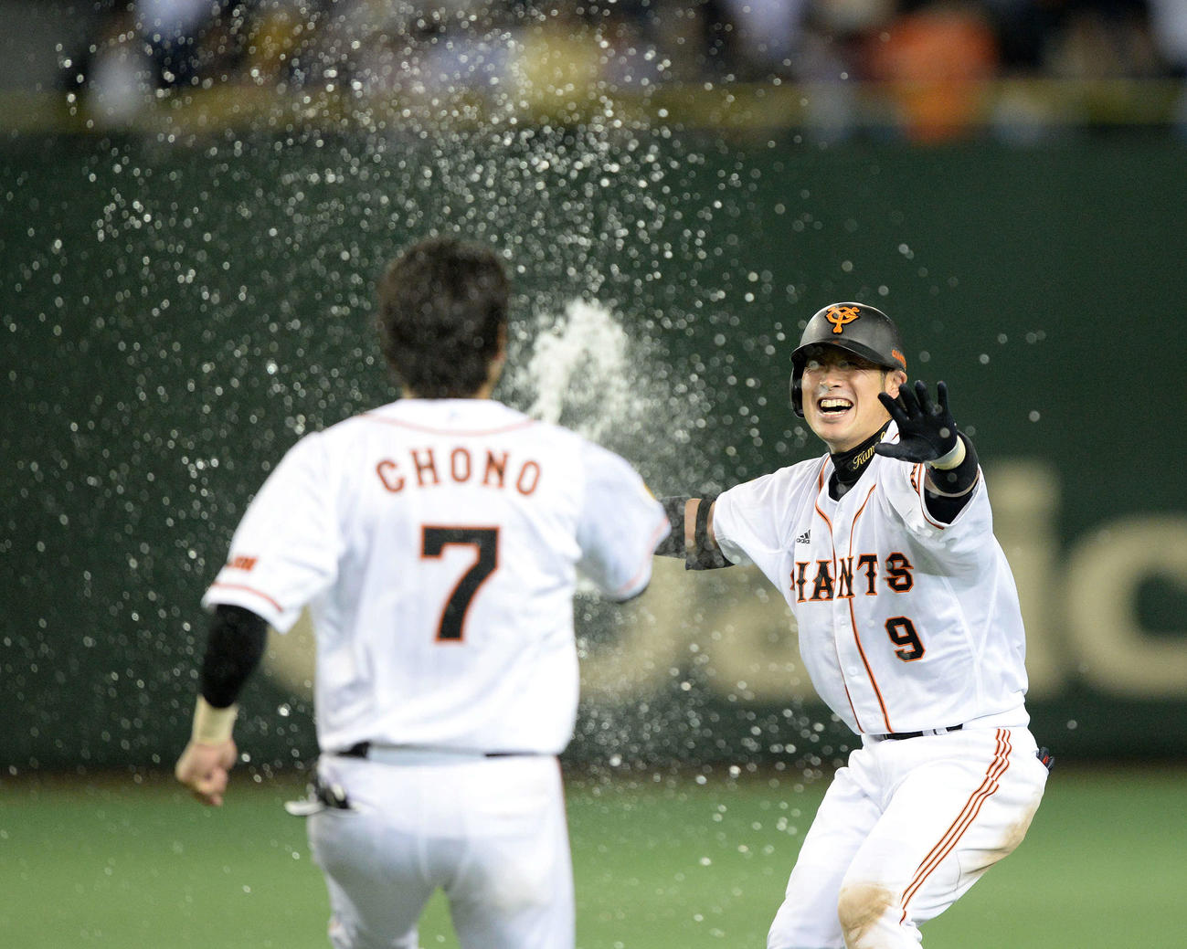 サヨナラ2点中前適時打の亀井（右）は長野から水を掛けられる（13年5月25日）