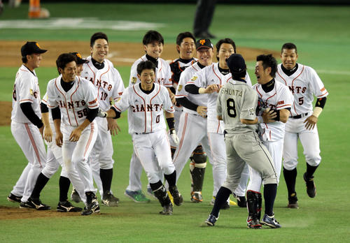 サヨナラの中前打を放ち、ナインから追いかけられる巨人亀井（手前右）はオリックス駿太と激突（13年5月25日）