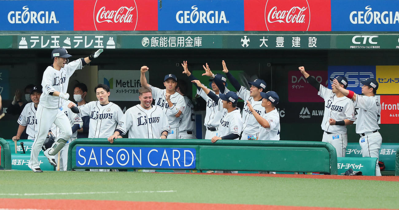 西武対日本ハム　2回裏西武無死、左越え本塁打を放った外崎（左端）はナインにエアタッチで迎えられる（撮影・足立雅史）