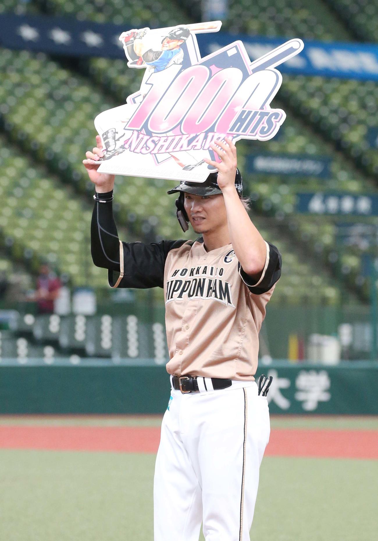 西武対日本ハム　4回表、通算1000本安打を達成し記念ボードを掲げる西川（撮影・黒川智章）