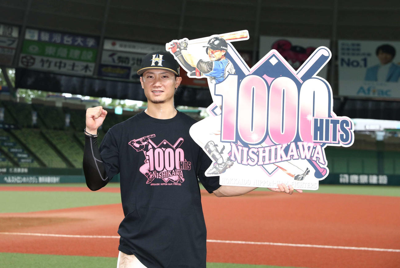 西武対日本ハム　プロ通算1000安打を達成した西川は記念ボードを笑顔で掲げる（撮影・黒川智章）