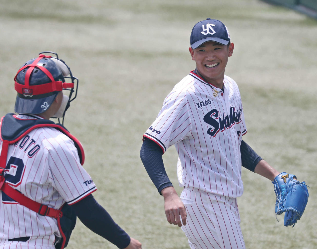 1回を無失点に抑えて笑顔でベンチに戻るヤクルト奥川（右）（球団提供）
