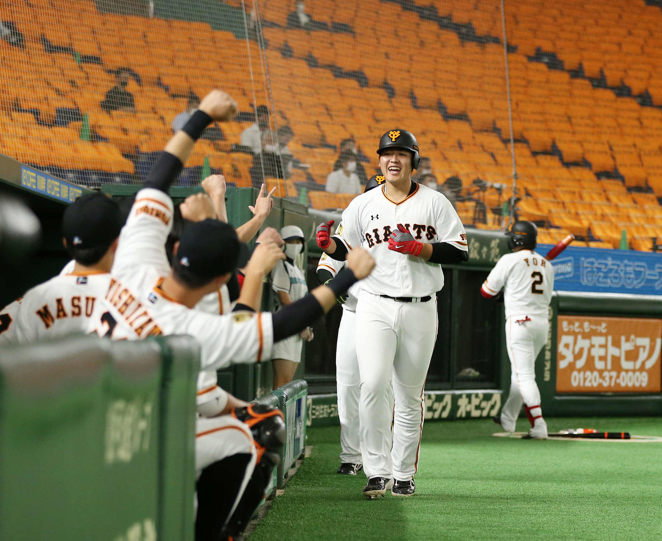 巨人対阪神　4回裏巨人無死一塁、右中間に2点本塁打を放ちベンチ前で笑顔を見せる岡本（撮影・河野匠）