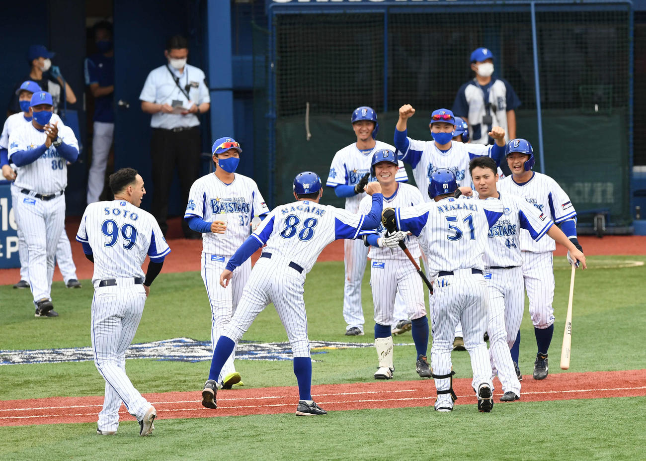 DeNA対広島　9回裏DeNA無死満塁、サヨナラ2点適時二塁打の宮崎（右手前）はチームメートから微妙な距離感で祝福される（撮影・山崎安昭）