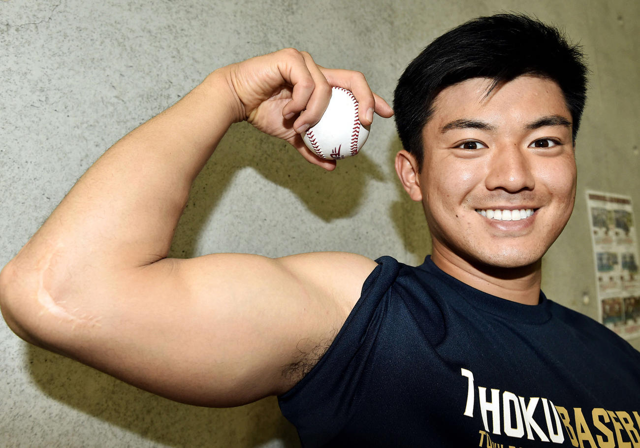 自慢の二の腕とマッスルカーブの握りを披露する楽天津留崎大成（2020年2月6日撮影）