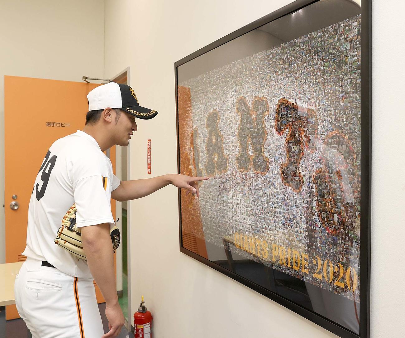 モザイクアートの写真を見つめる巨人吉川尚（球団提供）