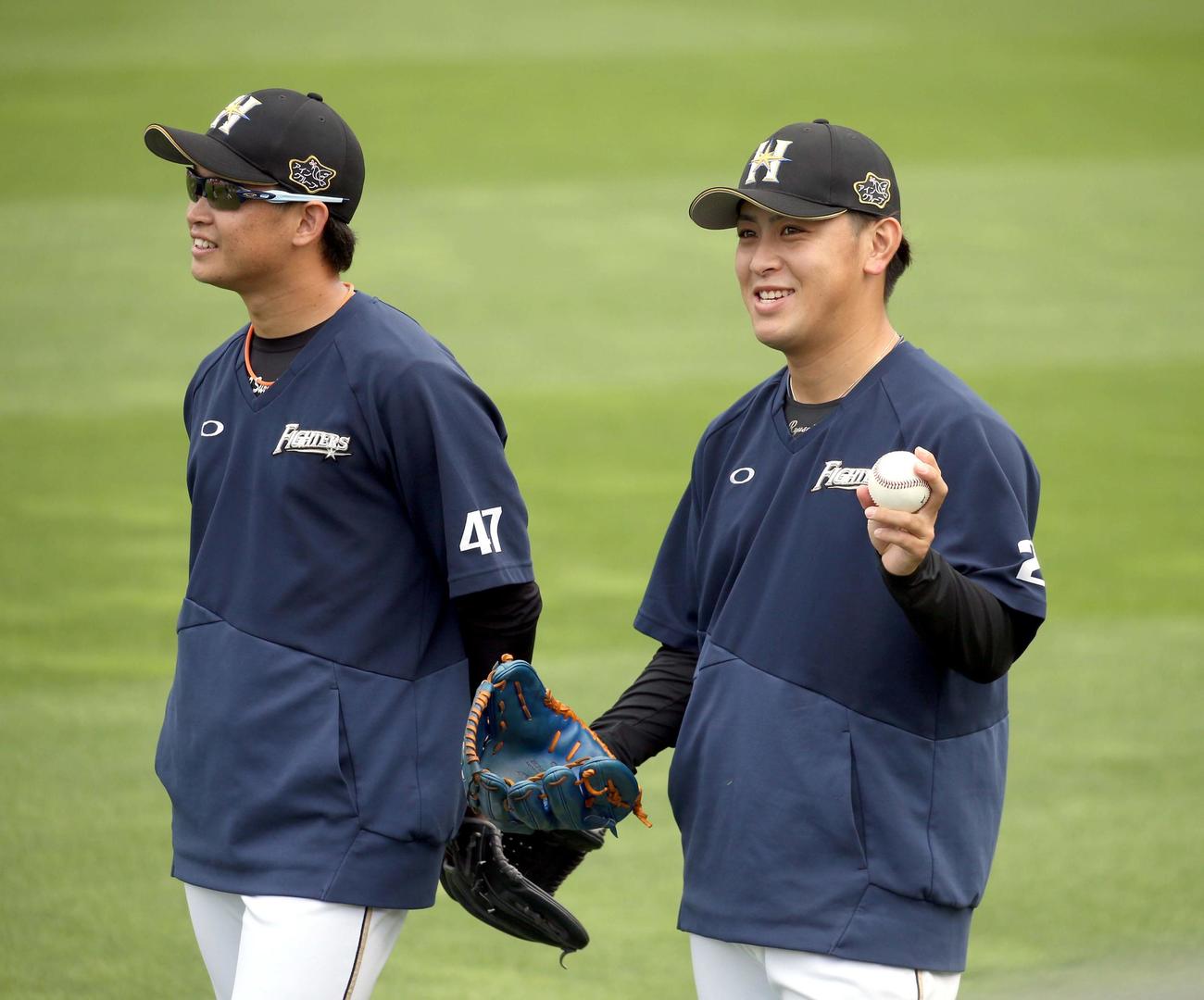 練習中、笑顔を見せる日本ハム鈴木健（左奥）と河野（撮影・佐藤翔太）