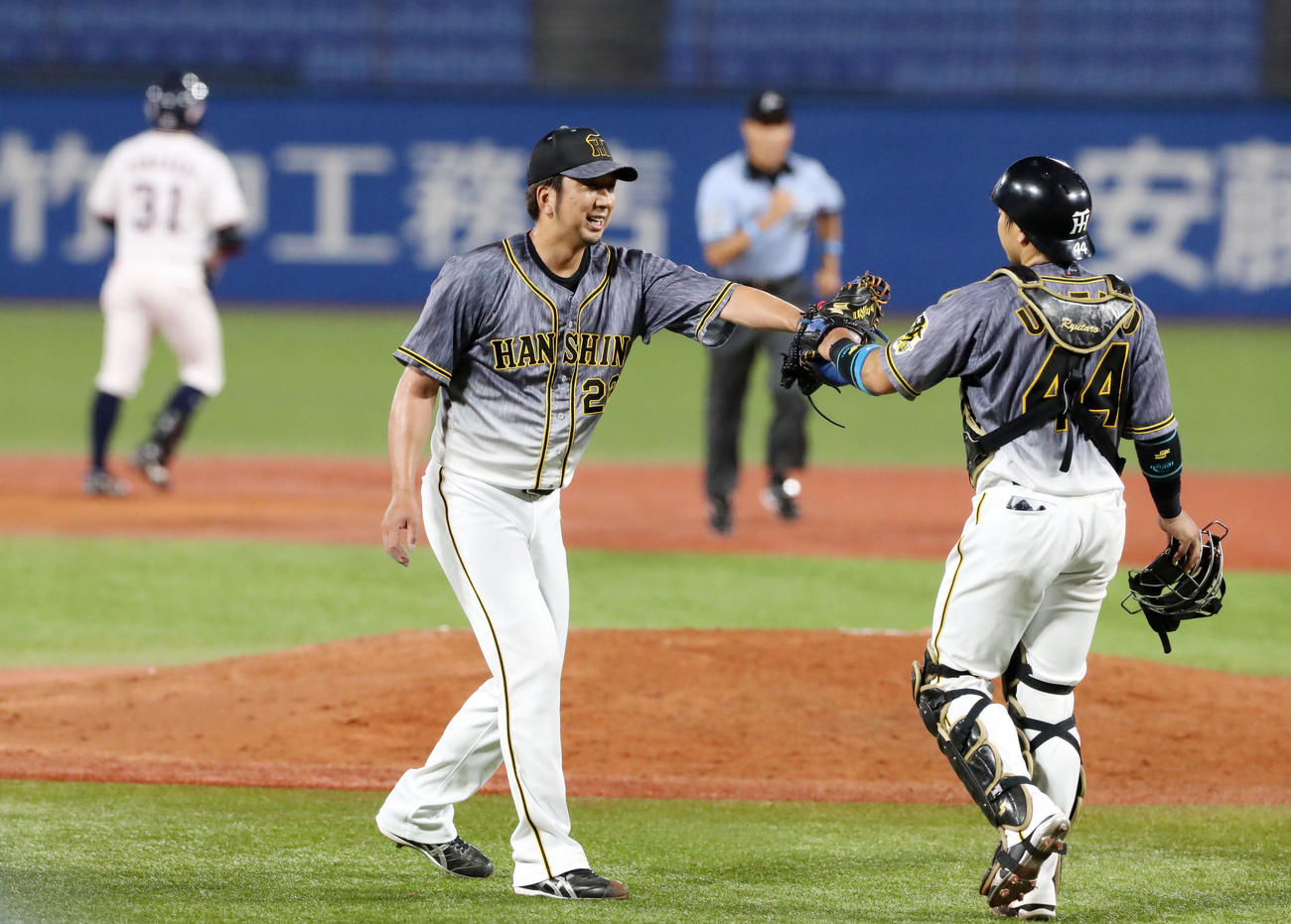 ヤクルト対阪神　ヤクルトに勝利し梅野（右）とグラブでタッチする藤川（撮影・加藤哉）