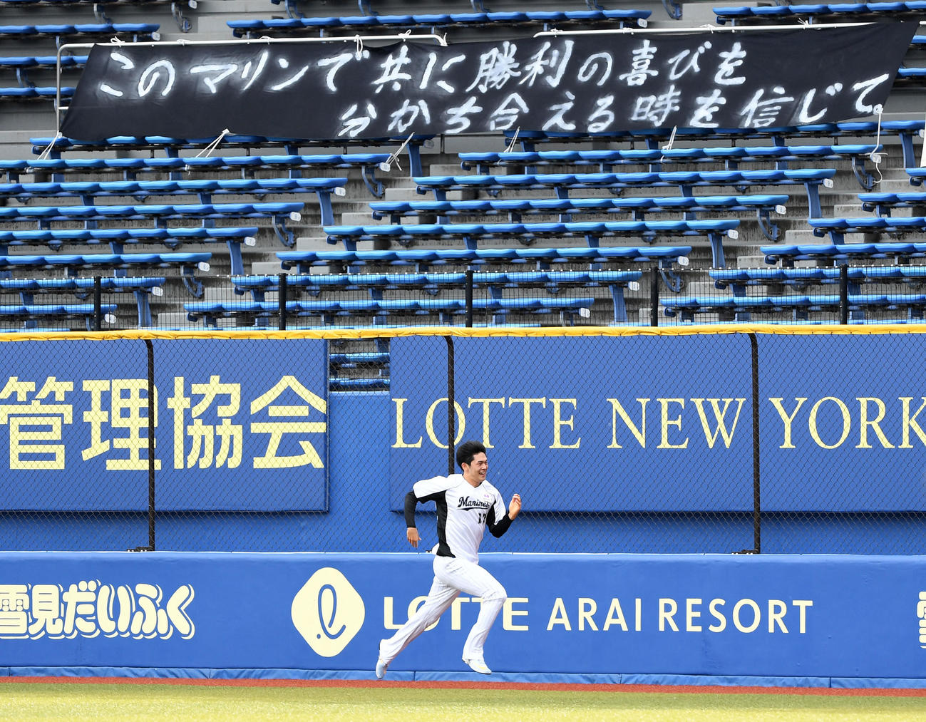 ロッテ対オリックス　横断幕を背にダッシュするロッテ佐々木朗（撮影・横山健太）