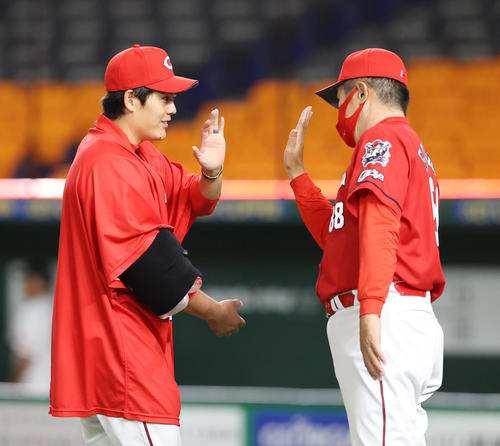 巨人対広島　巨人に勝利した広島九里（左）は佐々岡監督と笑顔でエアータッチ（撮影・垰建太）
