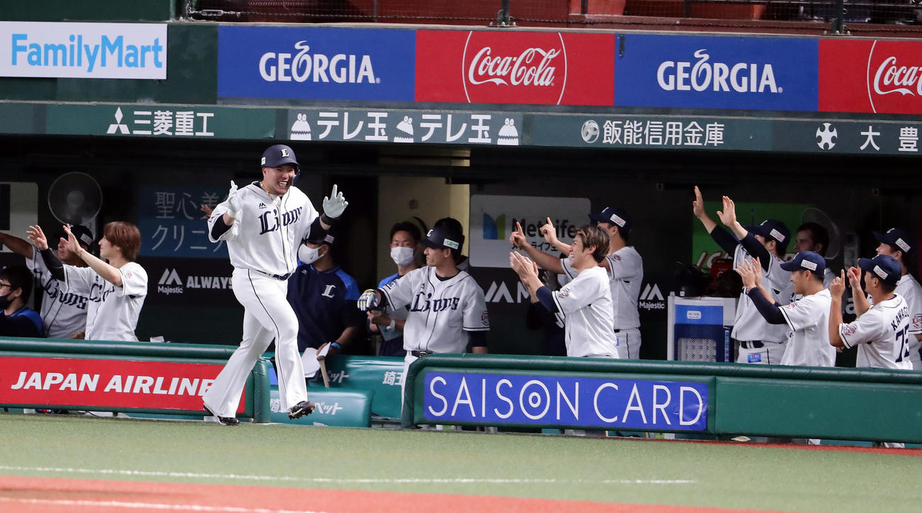 西武対ソフトバンク　1回裏西武1死一、二塁、山川（手前左）は右中間に3点本塁打を放ちポーズをつけてベンチ前で笑顔でエアハイタッチ（撮影・浅見桂子）