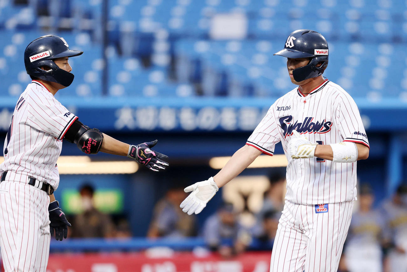 ヤクルト対阪神　1回表ヤクルト1死二、三塁、雄平の左犠飛で山田哲（右）が生還し山崎とエアタッチ（撮影・鈴木正人）