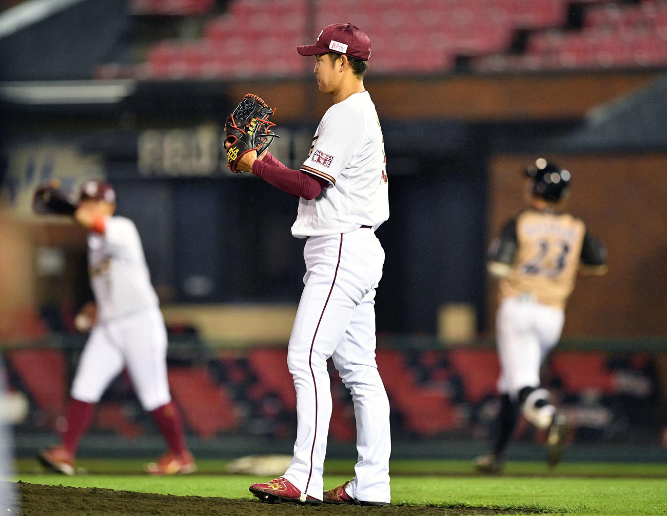 楽天対日本ハム　9回表日本ハム2死、渡辺（奥右）を遊ゴロに仕留めグラブをたたく森原（手前）（撮影・滝沢徹郎）