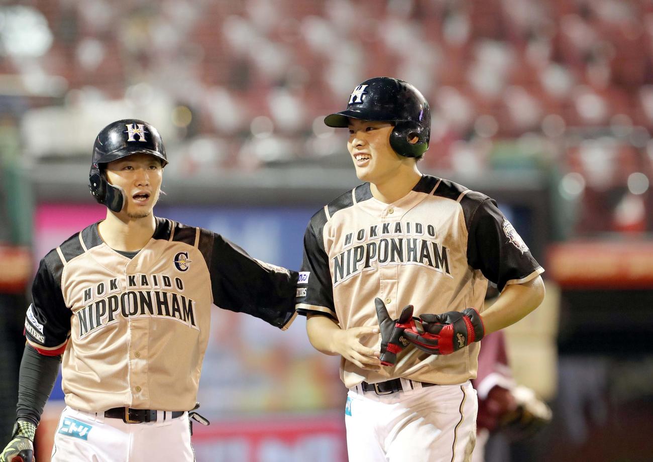 楽天対日本ハム　8回表日本ハム2死二塁、野村は適時三塁打を放ち西川（左）に出迎えられる（撮影・佐藤翔太）
