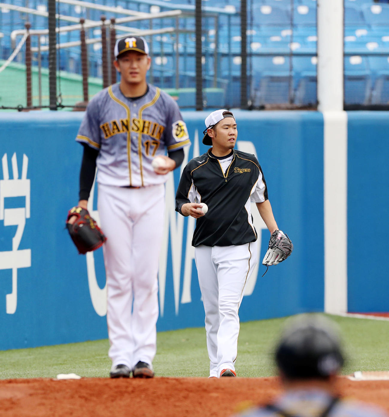 ヤクルト対阪神　練習を終え引き揚げる西勇、左はブルペンで投球練習する岩貞（撮影・加藤哉）
