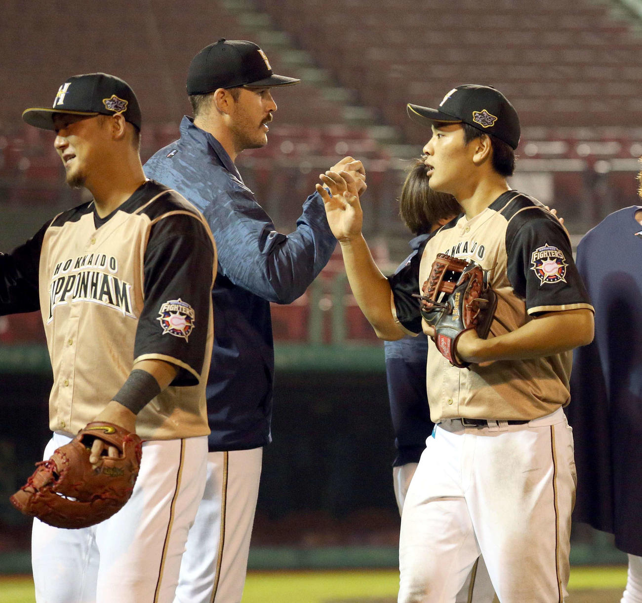 楽天対日本ハム　試合終了後、タッチを交わす日本ハム・バーヘイゲン（左奥）と野村（撮影・佐藤翔太）