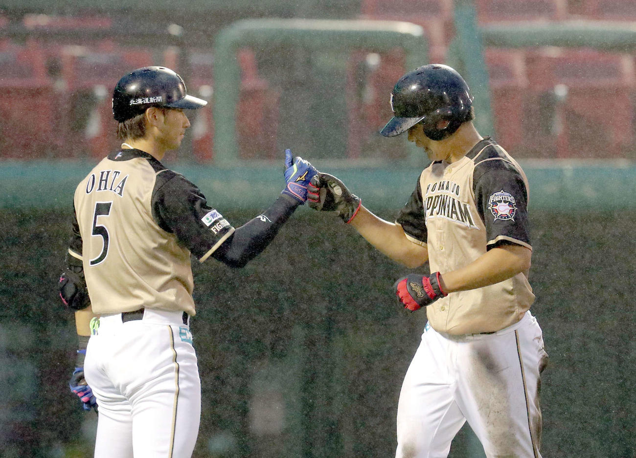 楽天対日本ハム　3回表日本ハム1死二塁、西川の左前適時打で生還し大田（左）とグータッチを交わす野村（撮影・佐藤翔太）
