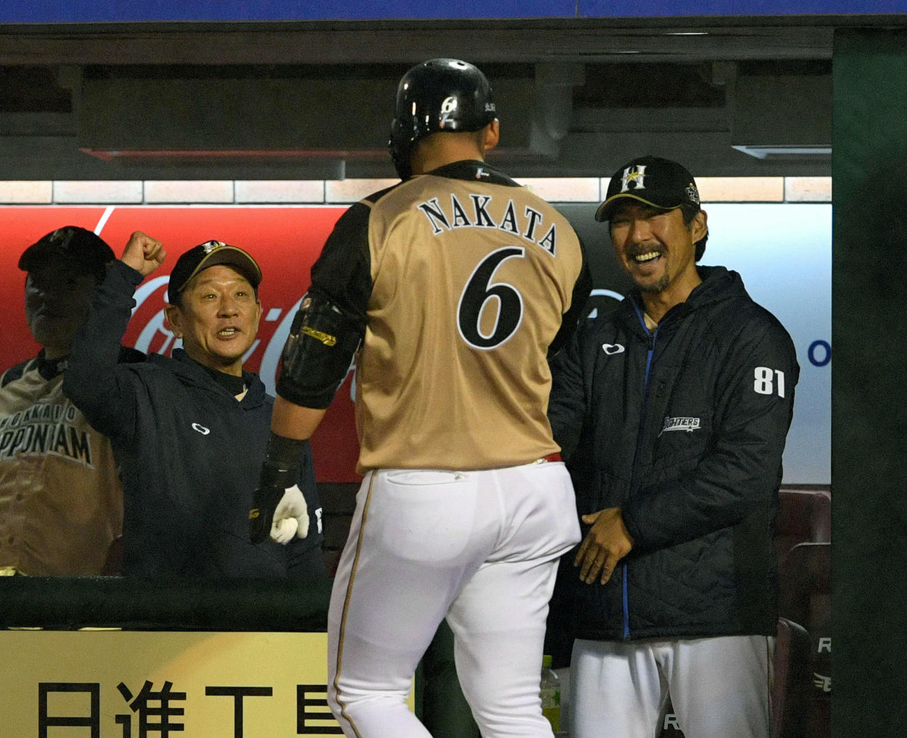 楽天対日本ハム　4回表日本ハム1死、中越えソロ本塁打を放った中田（手前）を出迎える栗山監督（左から）2人目と小笠原ヘッドコーチ（右）撮影・滝沢徹郎）