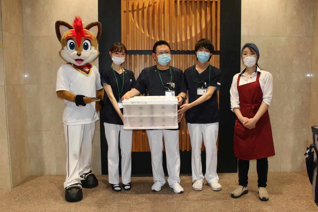 オーガニック弁当を手がける「OrganicKitchenChikyu」の石田香織さん（右）とともに札幌厚生病院へ弁当を届けた日本ハムのマスコット・フレップ（左）（撮影・木下大輔）