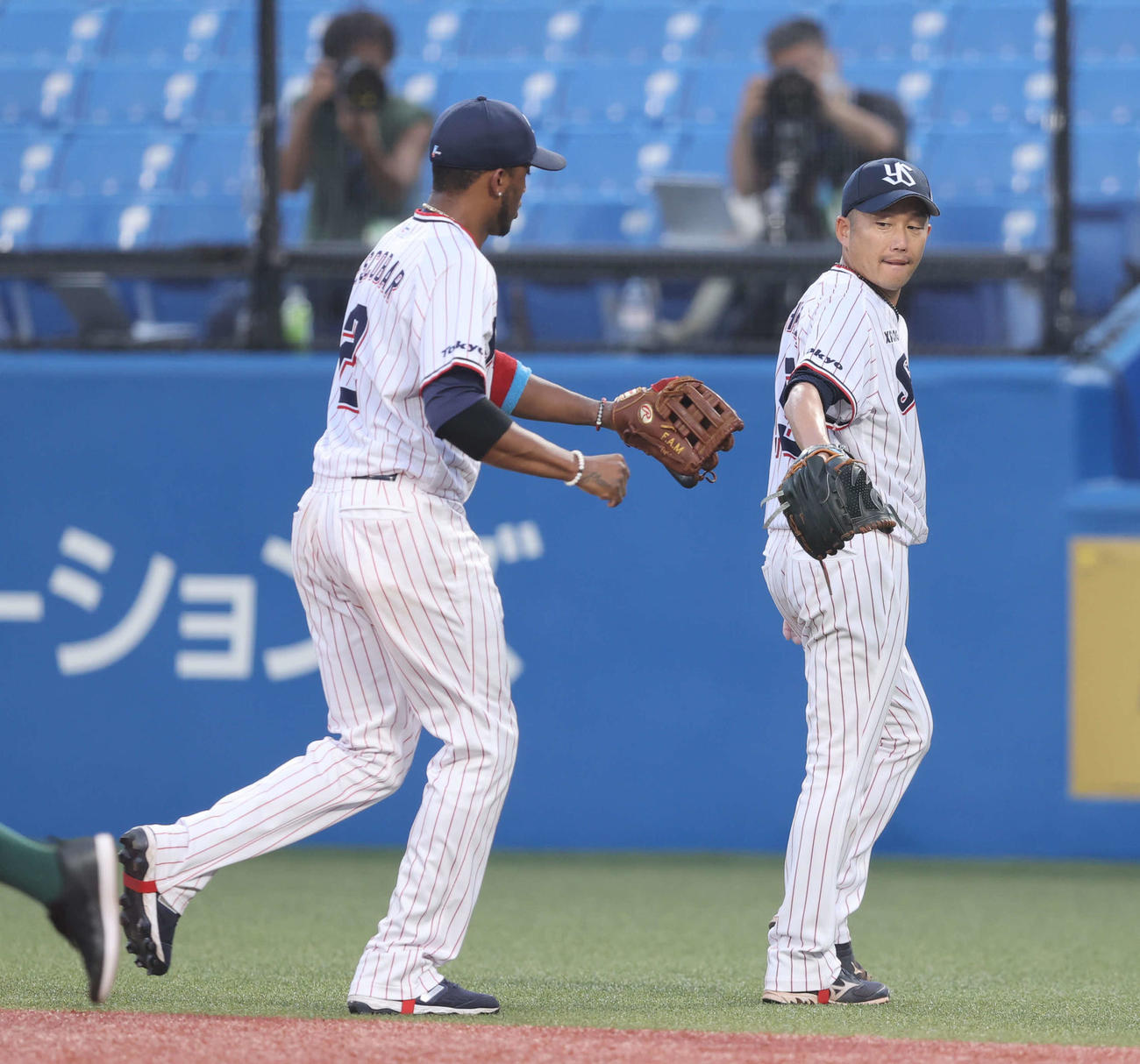 ヤクルト対巨人　2回表を終え、エスコバー（左）とグラブタッチを交わす石川（撮影・河野匠）