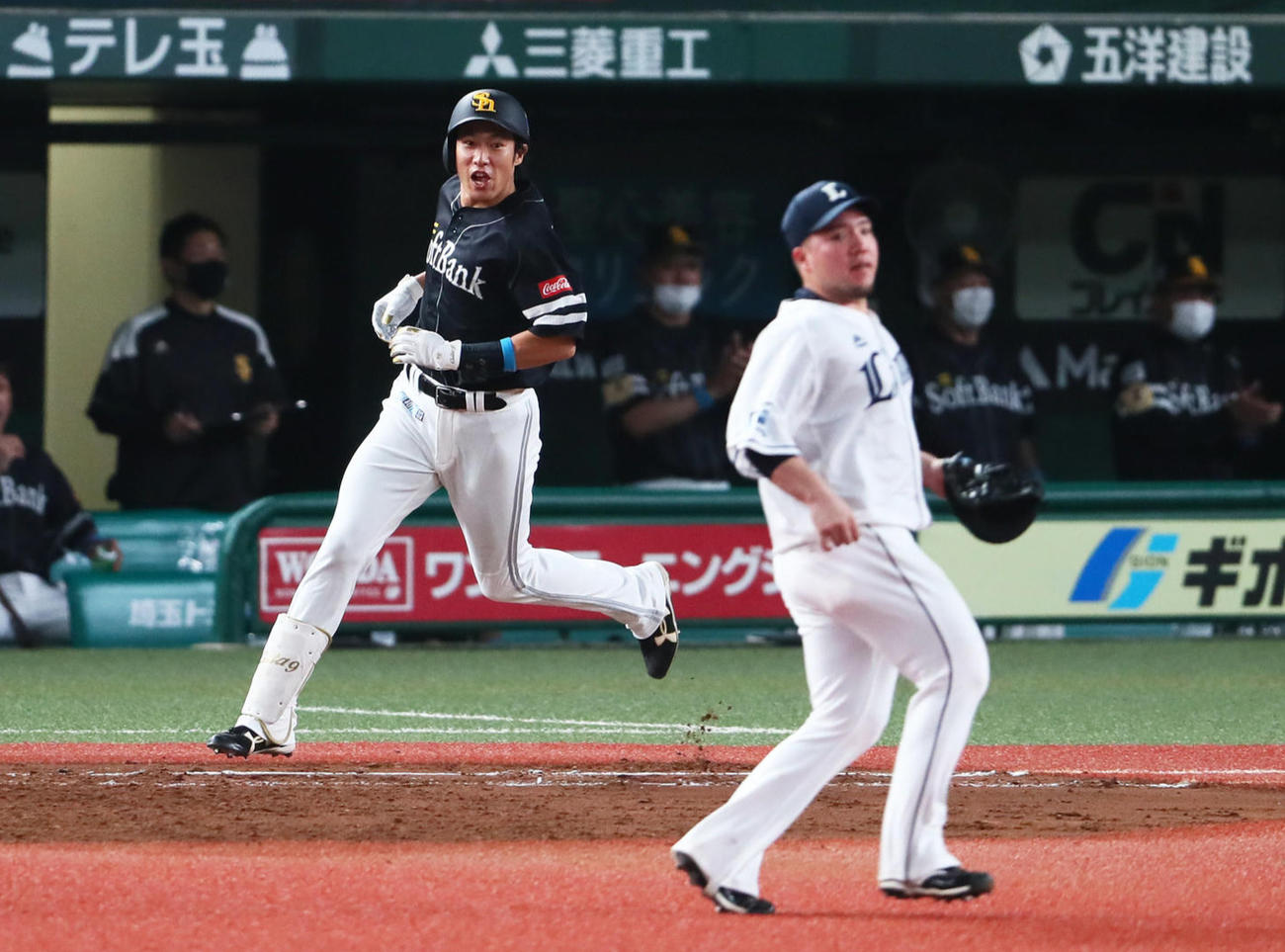西武対ソフトバンク　7回表ソフトバンク2死一、二塁、柳田（左）は勝ち越しの中前適時打を放ち一塁へと向かう。右は西武一塁手山川（撮影・足立雅史）