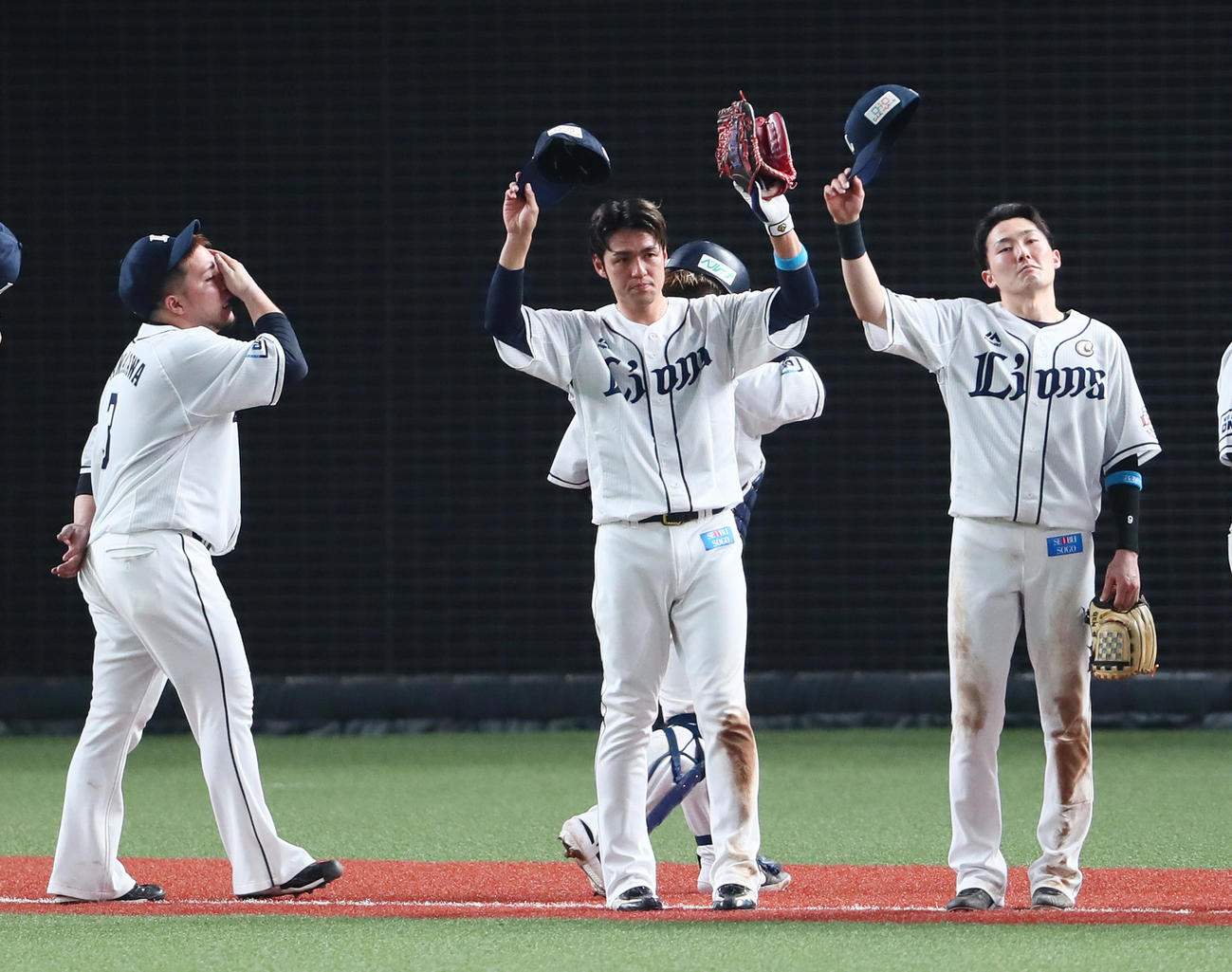 西武対ソフトバンク　8回逆転満塁弾の木村（中央）は無人のスタンドに向けて両手を上げる。左は疲労困憊（こんぱい）の表情を見せる山川（撮影・足立雅史）
