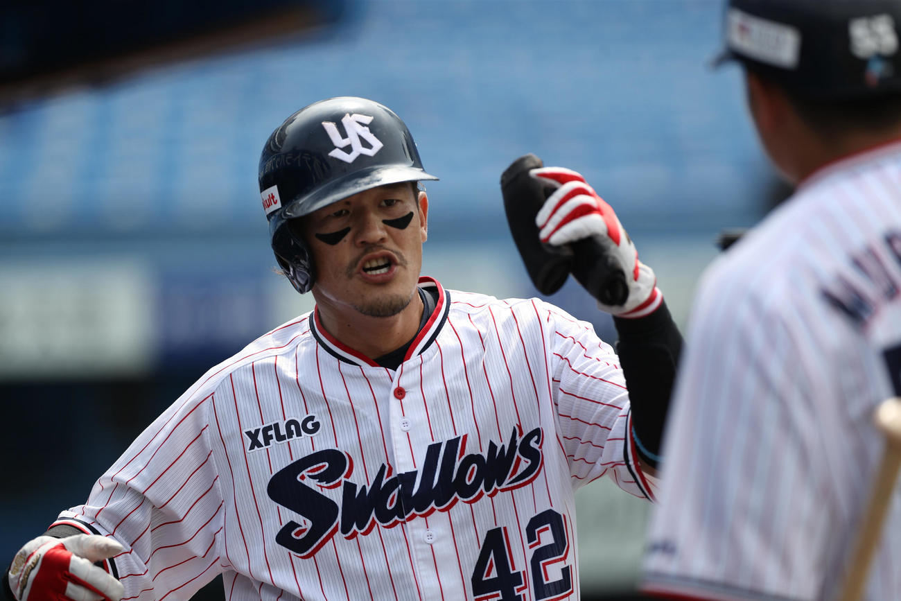 ヤクルト対巨人　1回裏ヤクルト無死二塁、山田哲の先制二塁適時打で生還し、ベンチに迎えられる坂口（撮影・狩俣裕三）