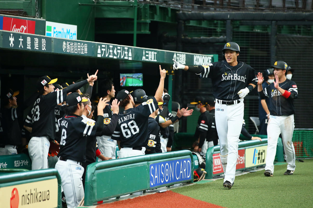 西武対ソフトバンク　1回表ソフトバンク無死一塁、柳田（左）は先制の中越え本塁打を放ちベンチの出迎えに笑顔を見せる（撮影・足立雅史）