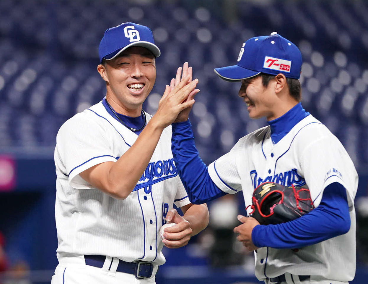 広島戦で勝利を挙げた吉見（左）は、最後を締めた岡田（右）から勝利球を受け取リ笑顔でタッチ（撮影・森本幸一）