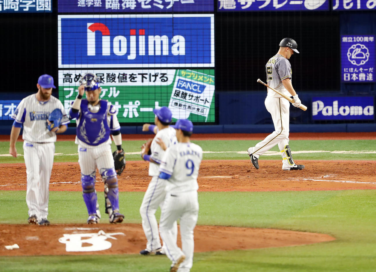 DeNA対阪神　9回表阪神2死一塁、サンズは見逃し三振に倒れ、喜ぶDeNAナインの奥をがっくり引き揚げる（撮影・浅見桂子）