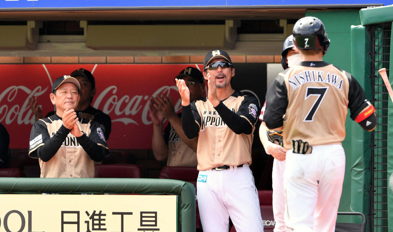 楽天対日本ハム　4回表日本ハム2死、右越えソロ本塁打を放った西川（手前）を出迎える日本ハム栗山監督（左手前）ら（撮影・滝沢徹郎）