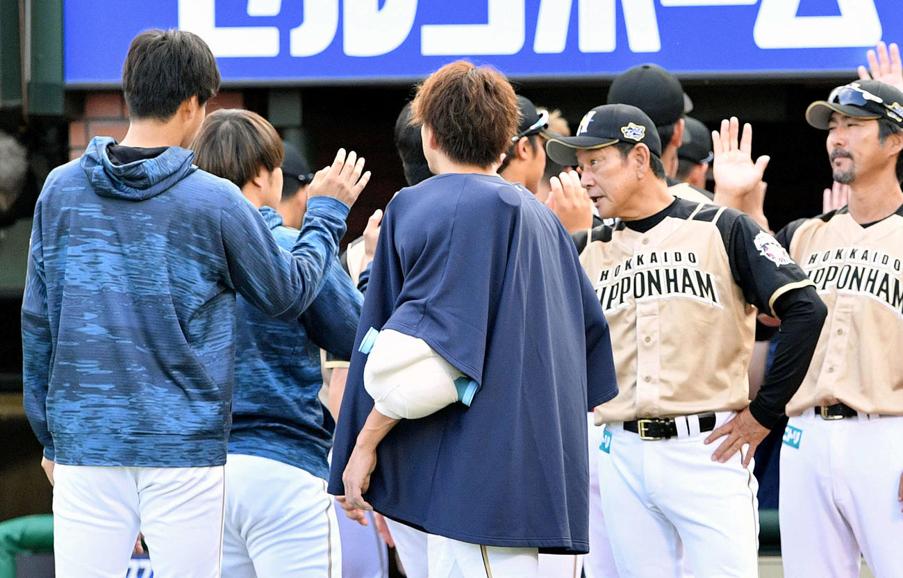 楽天対日本ハム　試合後、勝利投手の日本ハム杉浦（左）はとエアタッチを交わす栗山監督（右から2人目）（撮影・滝沢徹郎）