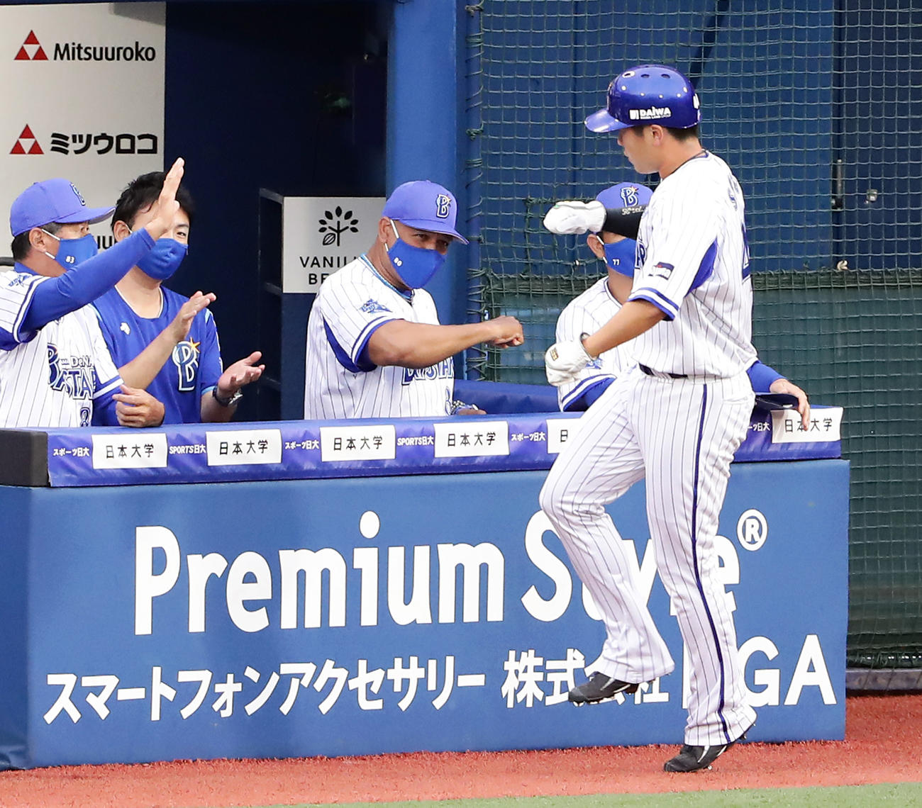 1回裏DeNA2死二塁、宮崎の中越え勝ち越し適時二塁打で生還した佐野（右）をエアグータッチで迎えるラミレス監督（中央）（撮影・浅見桂子）