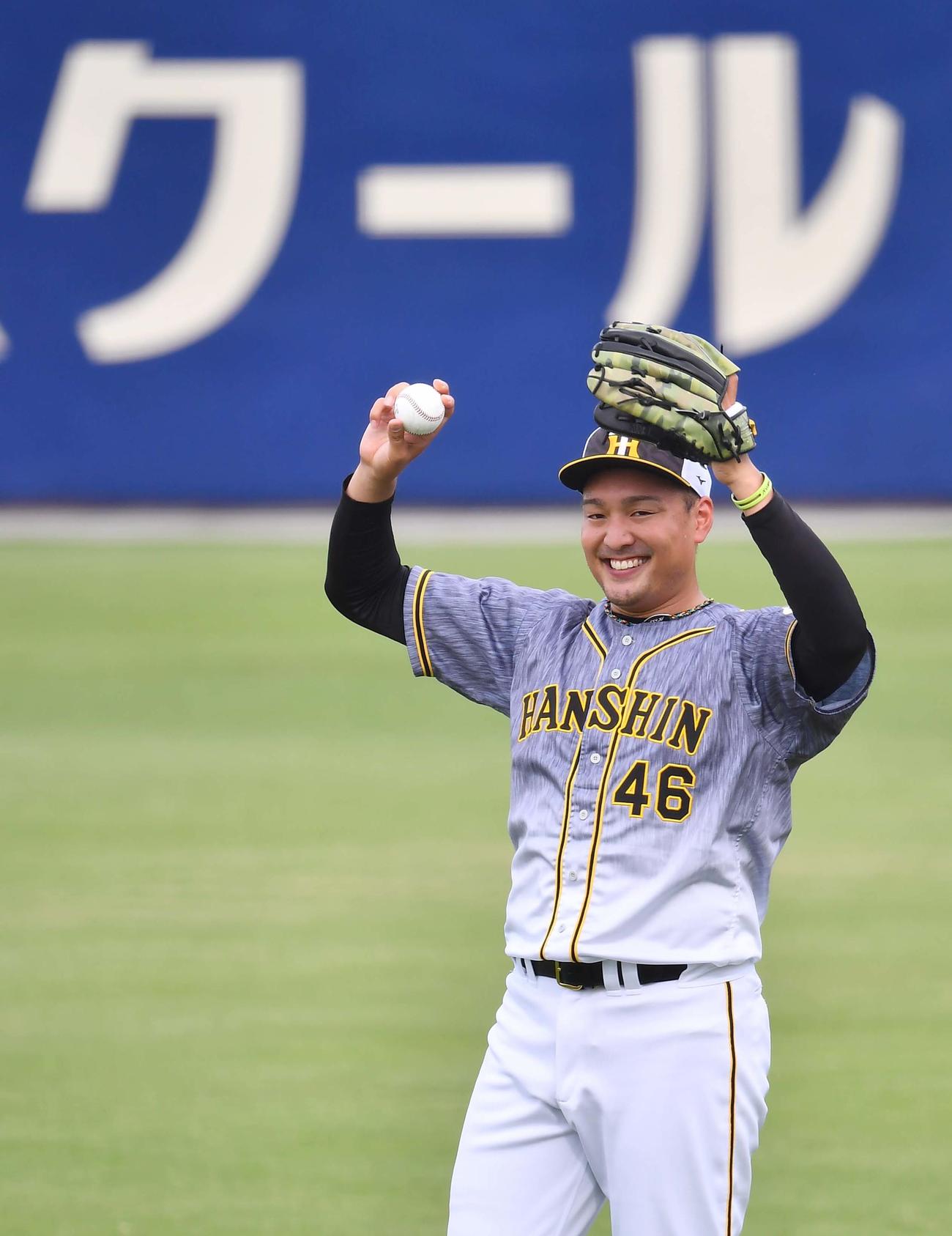 笑顔を見せながらキャッチボールをする秋山拓巳（撮影・上田博志）