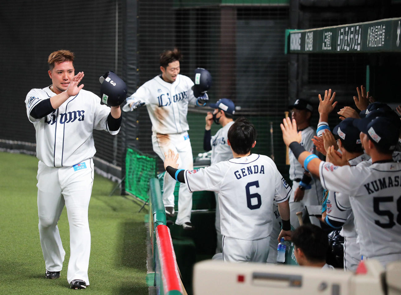 西武対オリックス　4回裏西武2死満塁、栗山の先制2点適時打で生還し、ナインとエアタッチをする山川（左）（撮影・河田真司）　