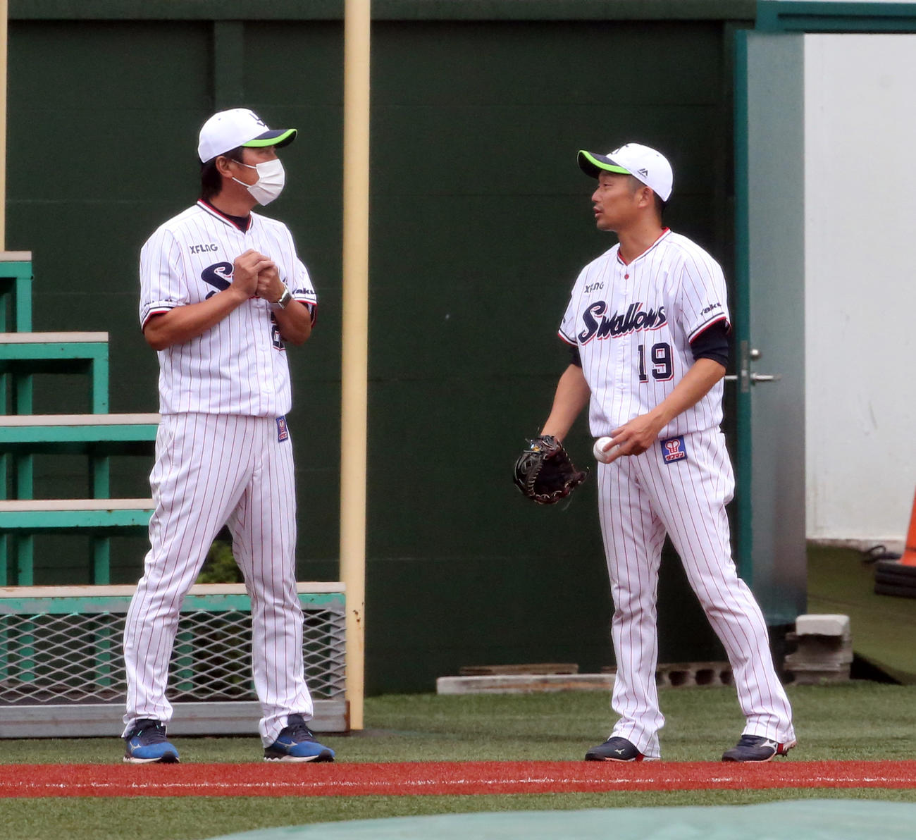 ヤクルト対広島　キャッチボール前、話し込むヤクルトの高津監督（左）と石川（撮影・浅見桂子）
