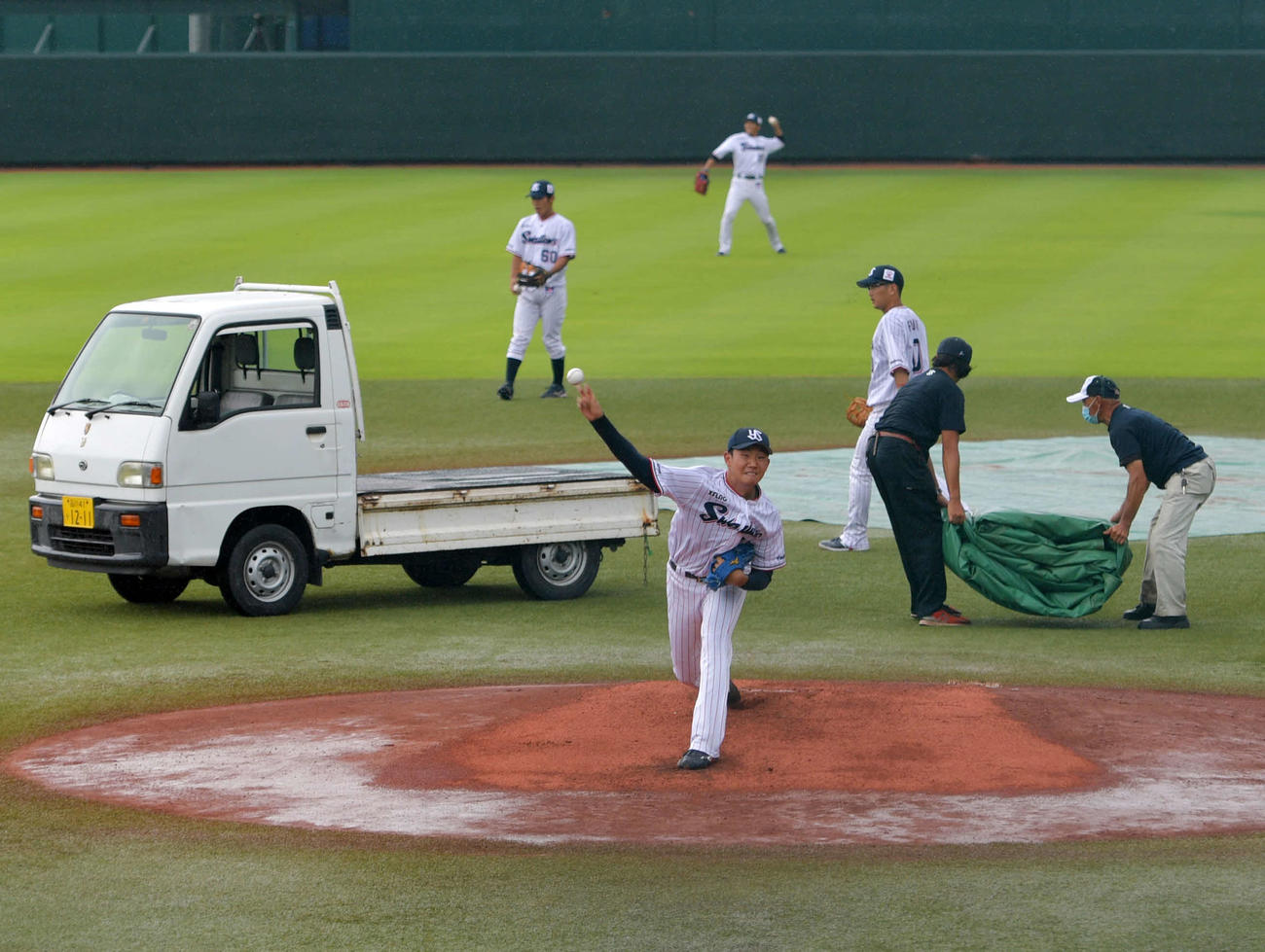 イースタン・リーグ　ヤクルト対ロッテ　雨による一時中断後、再開を待って投球練習するヤクルト奥川（手前）（球団提供）